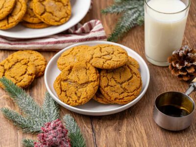 A plate full of molasses cookies with another in the background.