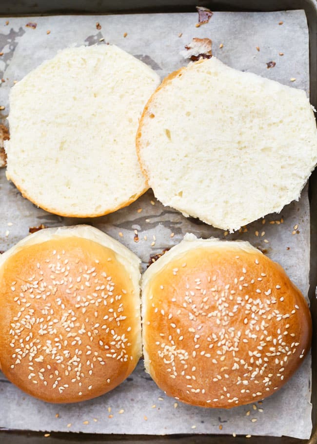 bun sliced in half on a baking sheet