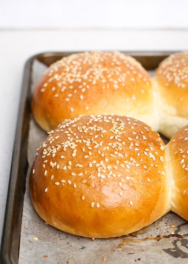 homemade hamburger buns on a baking sheet