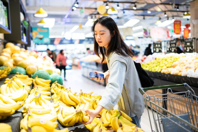 asian girl buy fruit in supermarket