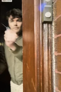 Nick Fuentes spraying "some form of liquid" at a woman knocking at his door. Photo taken from a screenshot of a video posted on Facebook by Marla Rose