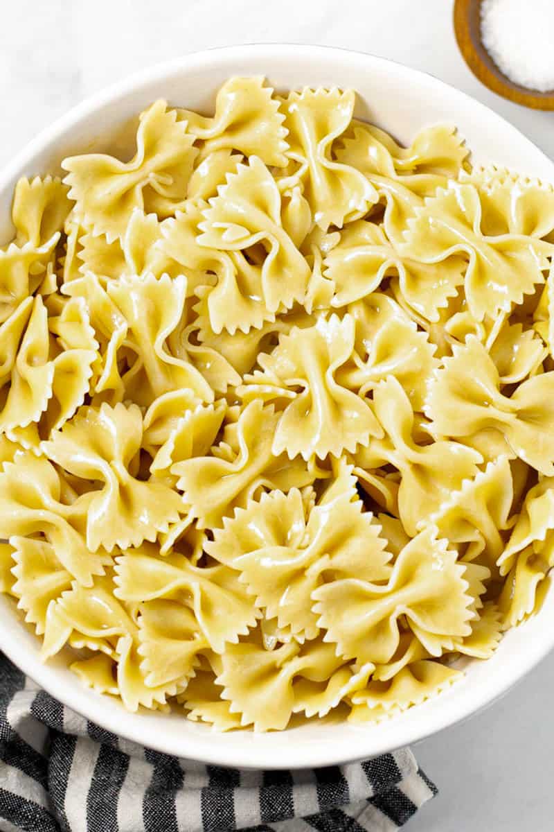 Large white bowl filled with cooked bowtie pasta