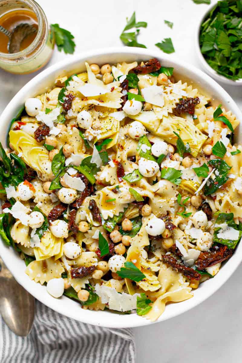 Overhead shot of a bowl of sun dried tomato pasta salad garnished with fresh parsley 