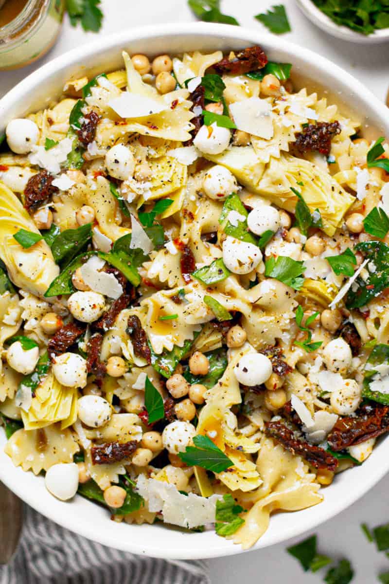 Overhead shot of a bowl of sun dried tomato pasta salad garnished with fresh parsley 