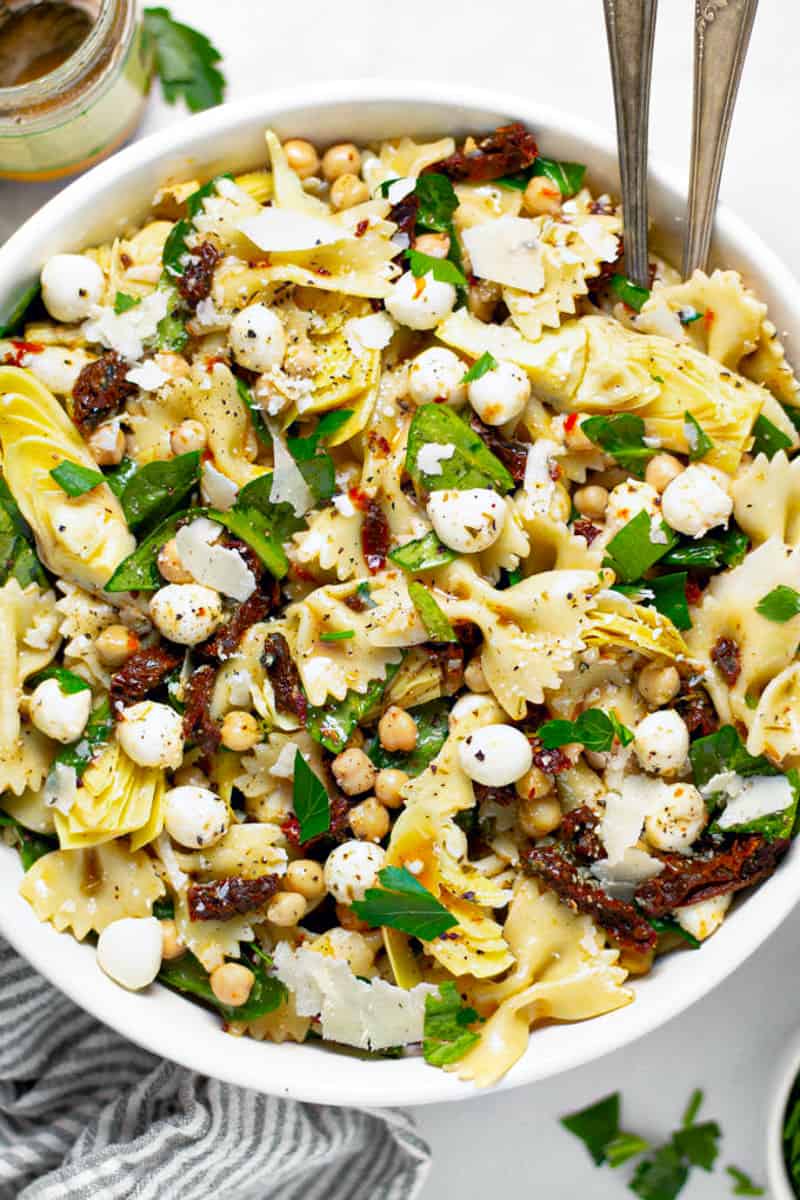 Overhead shot of a bowl of sun dried tomato pasta salad garnished with fresh parsley 