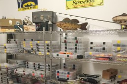 Well organized shelves with stacks of Plano tackle box inserts on wire racks. Off-season prep gets things ready for spring success!