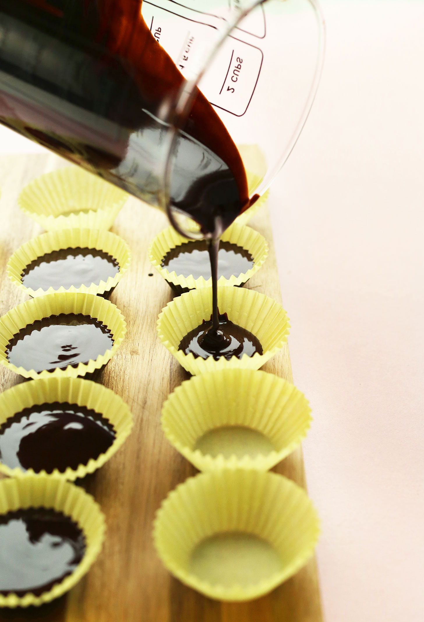 Pouring homemade vegan chocolate into baking cups