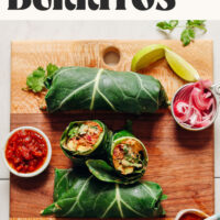 Vegan collard green burritos with fillings on a wood cutting board