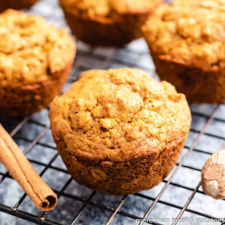 Four pumpkin oatmeal muffins on a cooling rack.