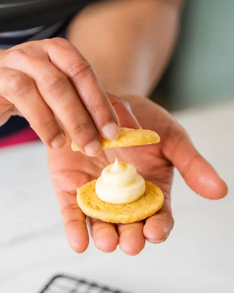 To fill the biscuits, pipe a little mound of the filling onto the base of one biscuit, before using a second one to push the filling out evenly to the edges. And your sandwich cookie is done! Recipe by movers and bakers