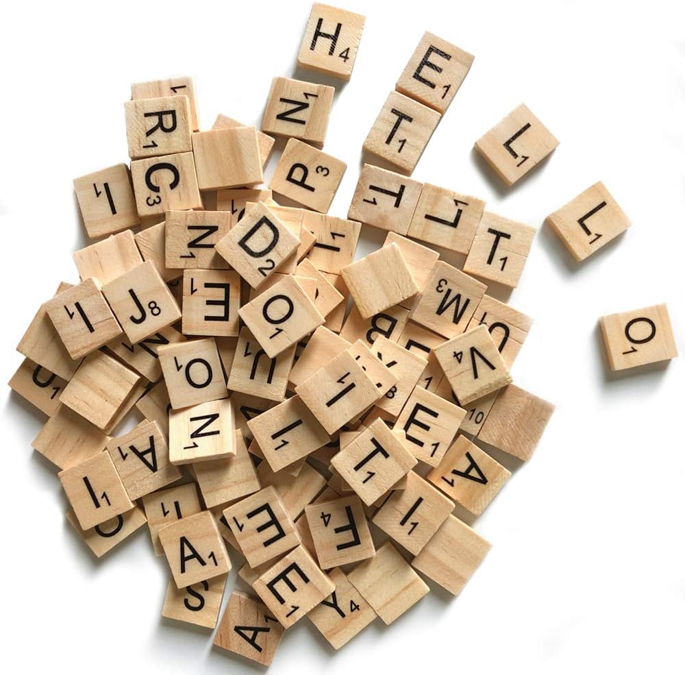 A pile of wooden Scrabble tiles scattered randomly, perfect for sparking creative ideas for gift wrapping.