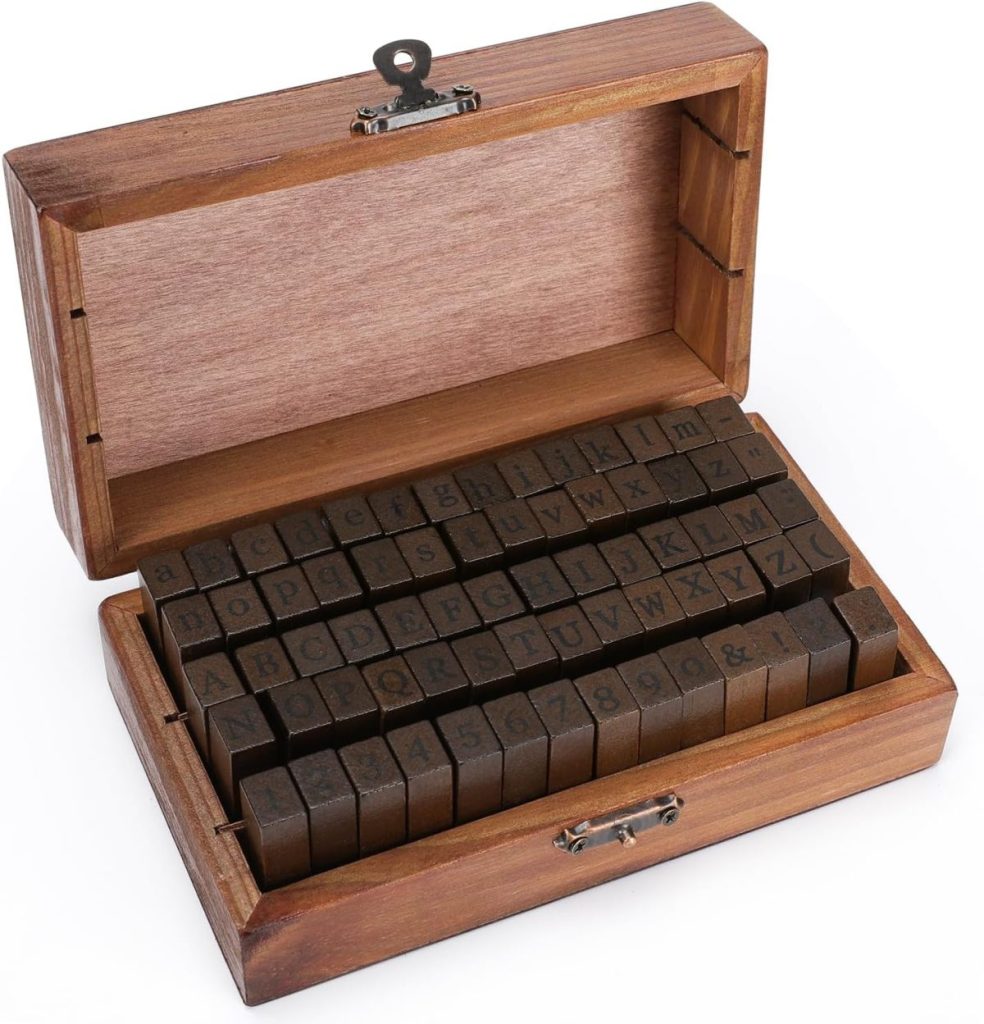 Wooden box containing neatly arranged rubber alphabet stamps and numbers, perfect for adding a personal touch to your gift wrapping. Box is open with stamps visible.