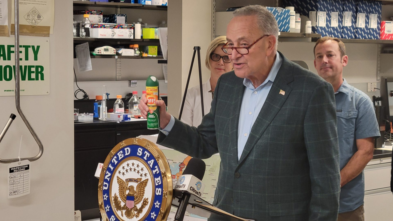 Senator Chuck Schumer is holding a bottle of bug repellent