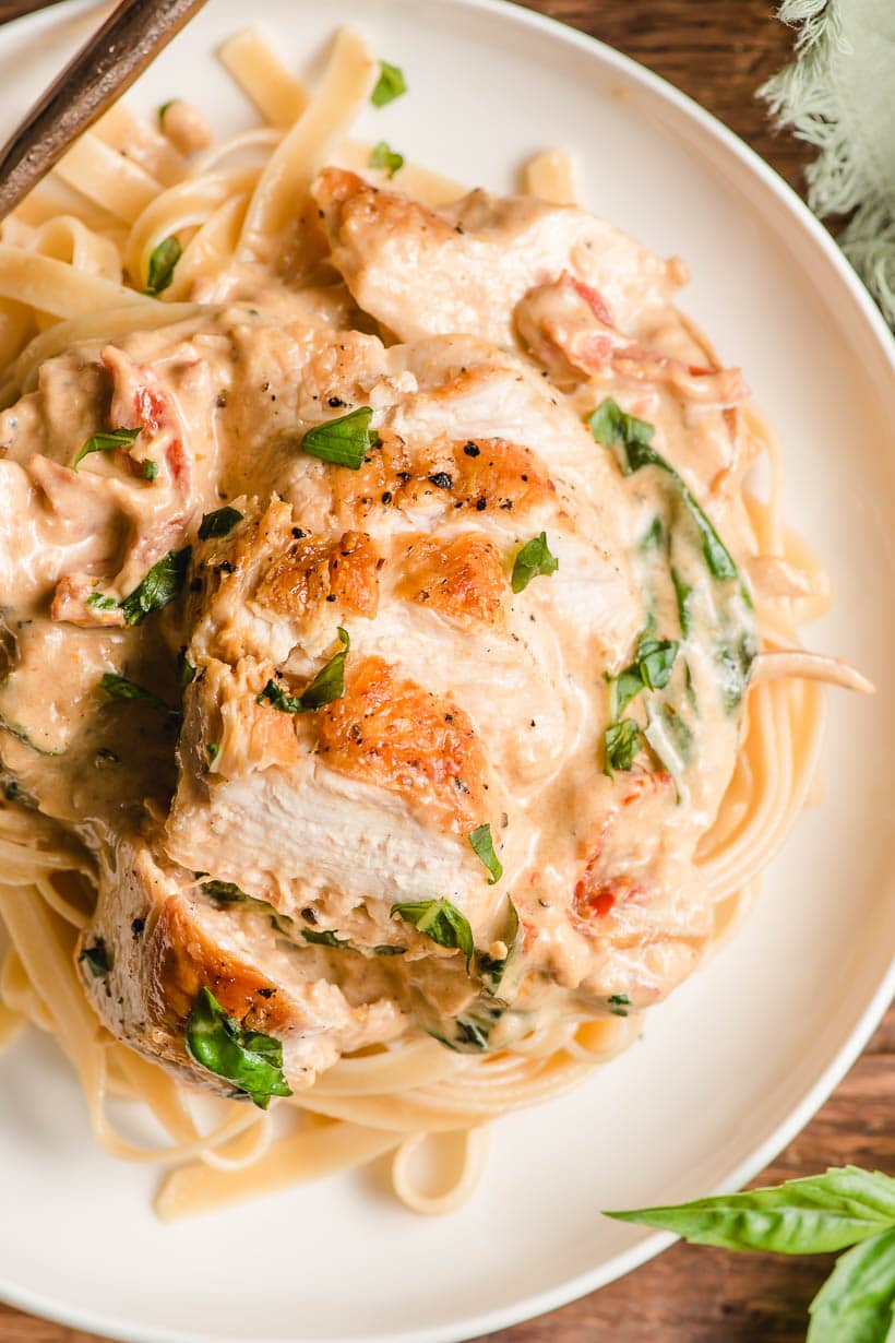 Sauteed chicken breast plated on top of sun dried tomato fettuccine.