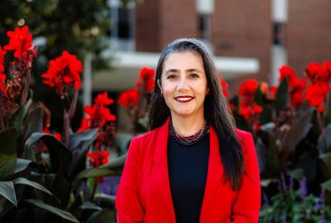 provost standing in front of flowers