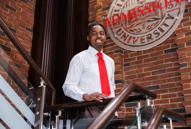 person standing on stairs in front of Illinois State seal