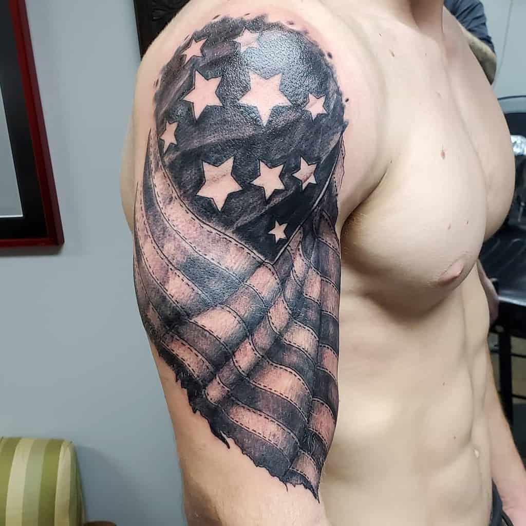 Man with a tattoo of a stylized American flag on his upper arm and shoulder