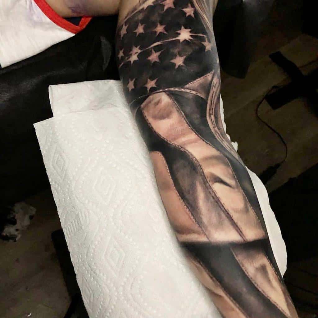 Sleeve tattoo of a flowing American flag on an arm