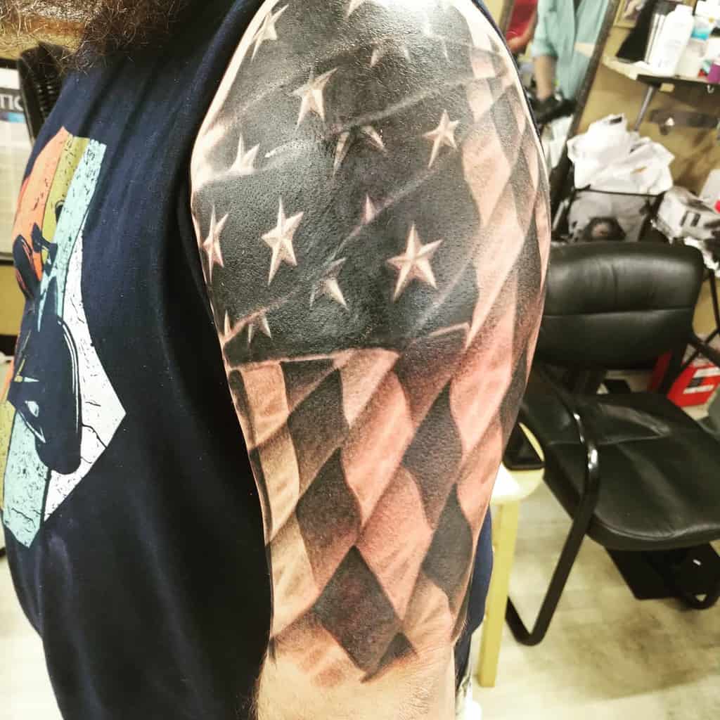 Tattoo of an American flag on a man's upper arm 