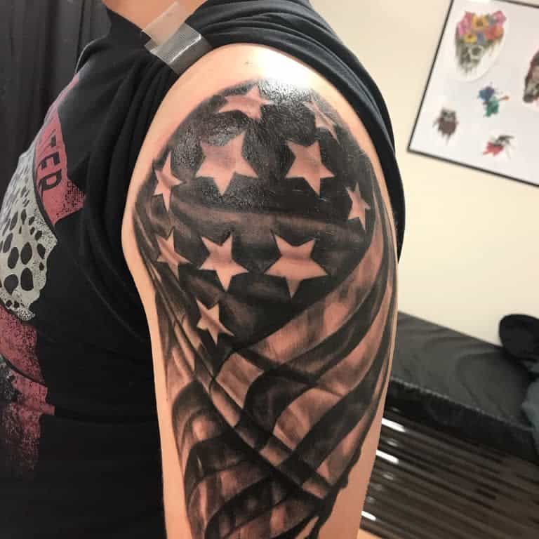 Arm tattoo of a stylized American flag with stars and stripes