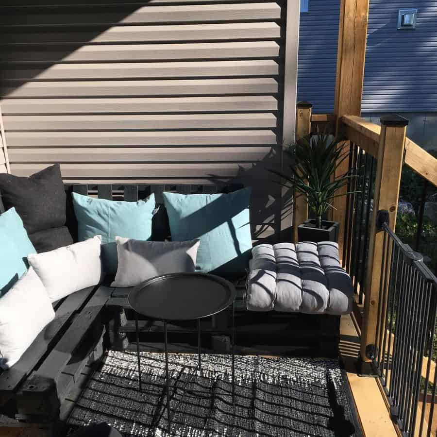 small diy patio with black painted wooden pallet seats