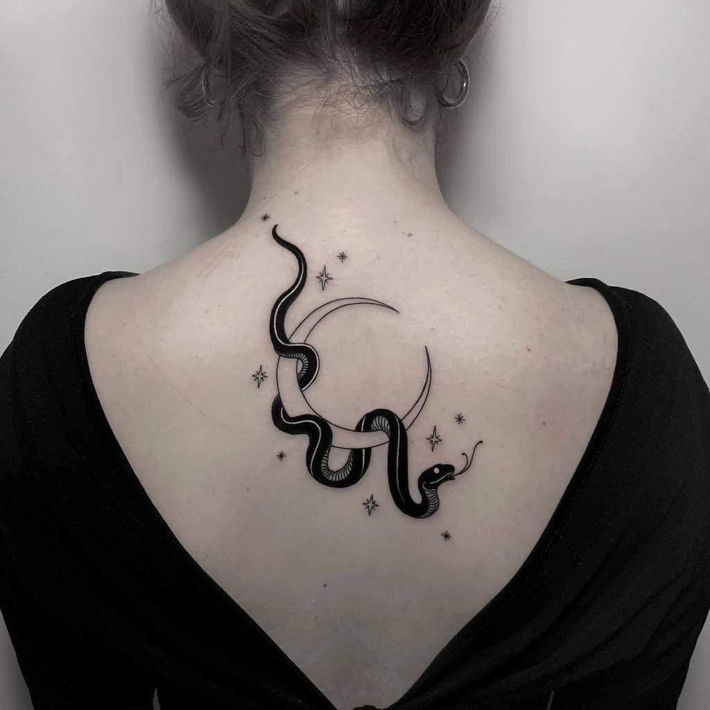 Crescent moon and stars tattoo with intricate snake design on upper back