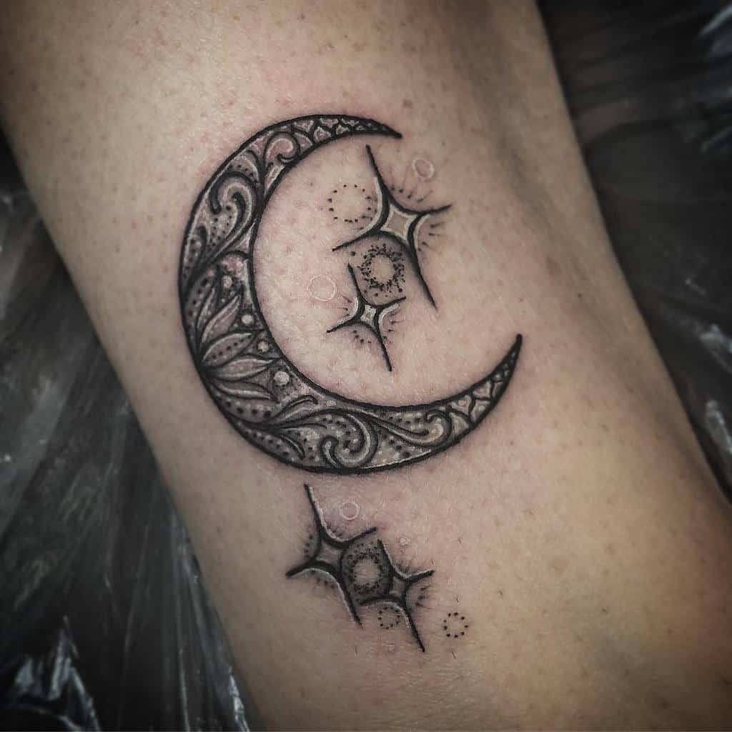 Intricate crescent moon tattoo with stars and ornate details