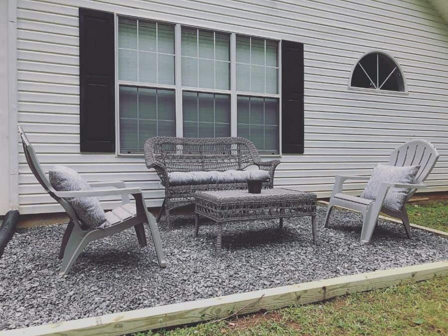 small gravel patio with gray wicker furniture 