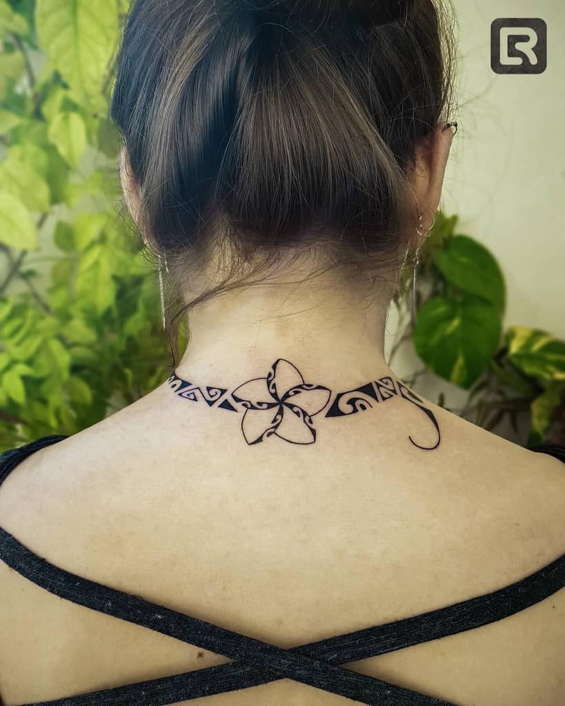 A woman with a striking floral and tribal tattoo graces her neck