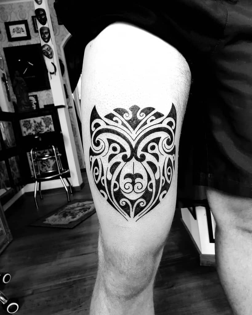 A beautifully intricate tribal tattoo adorns a person's upper thigh, showcasing exquisite artistry and bold design