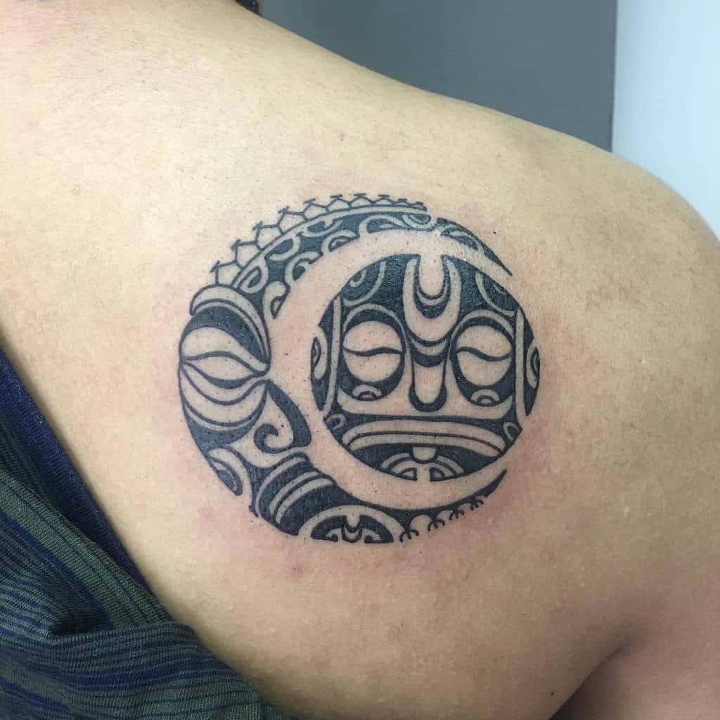 Tribal tattoo of the sun and moon on a shoulder