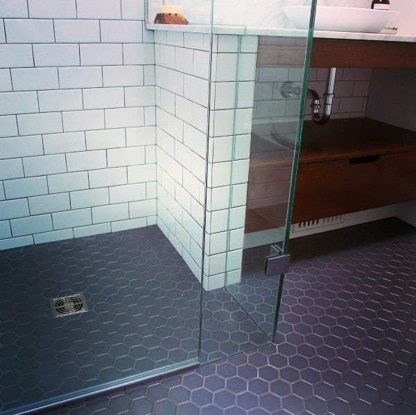 Shower with grey hexagonal floor tiles, white subway wall tiles, and glass enclosure.