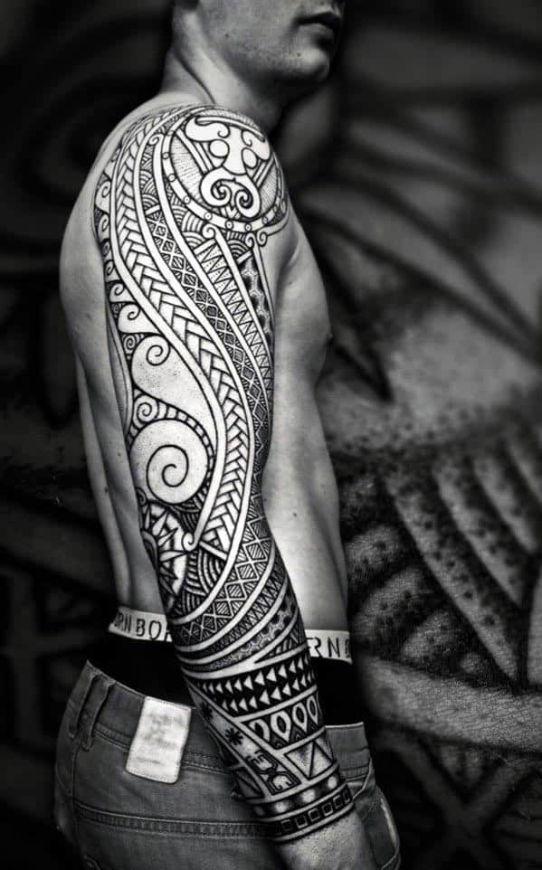 Man with detailed tribal sleeve tattoo on his arm and torso