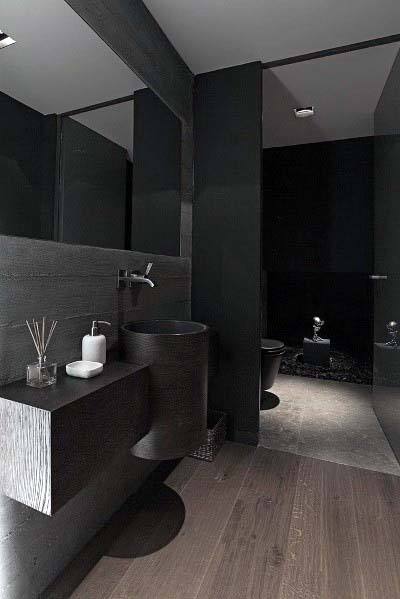 Modern black bathroom with floating sink and wooden floor.