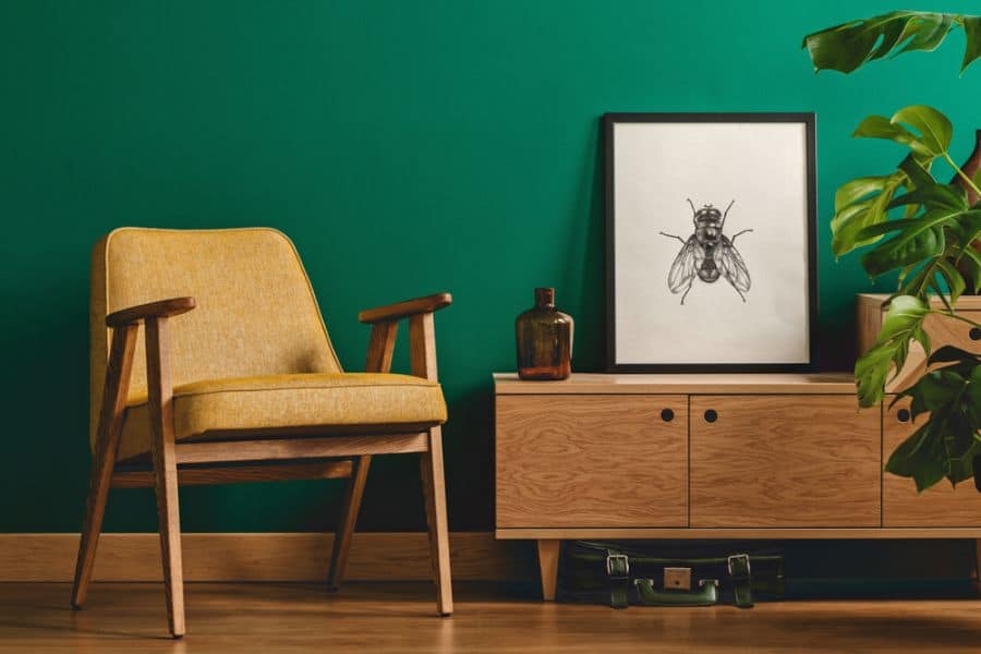 green accent wall and yellow chair in living space