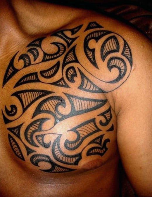 Shoulder tattoo with bold, intricate tribal patterns in black ink