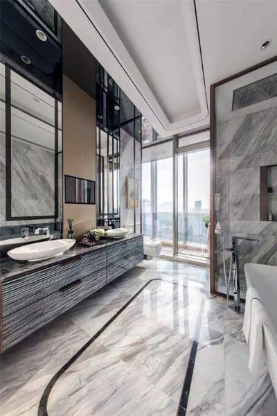 Luxury bathroom with marble floor tiles, large vanity, and floor-to-ceiling windows.