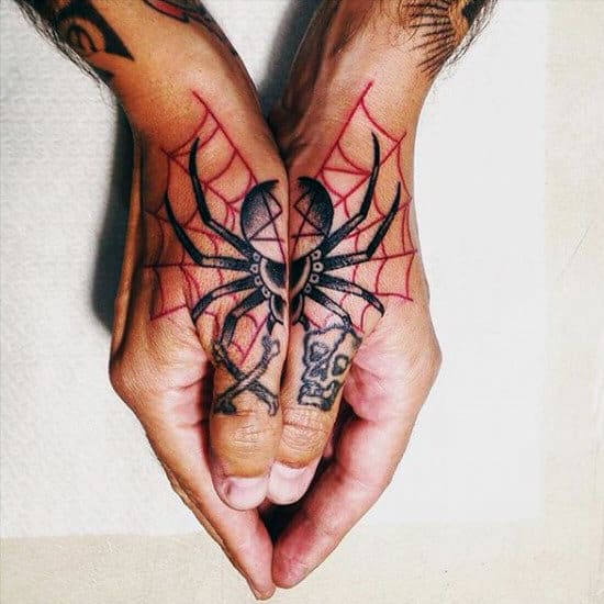 Hands with tattoos of a spider and web on fingers, joined to form a complete spider image