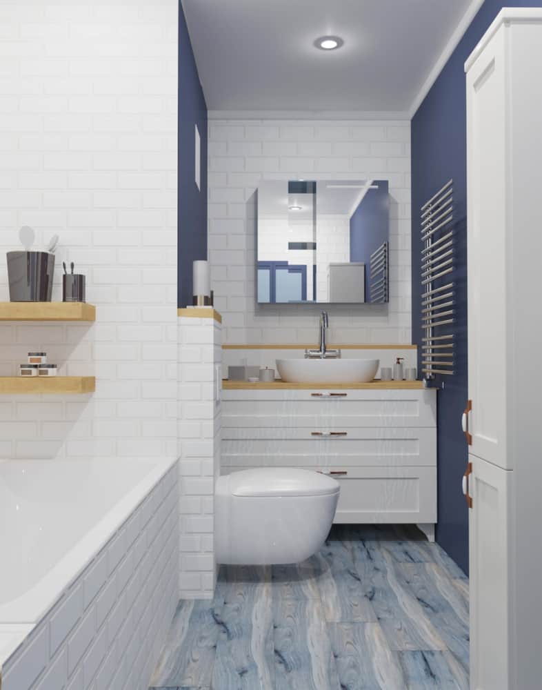 Blue and white bathroom with wood accents, white brick tiles, and floating sink.