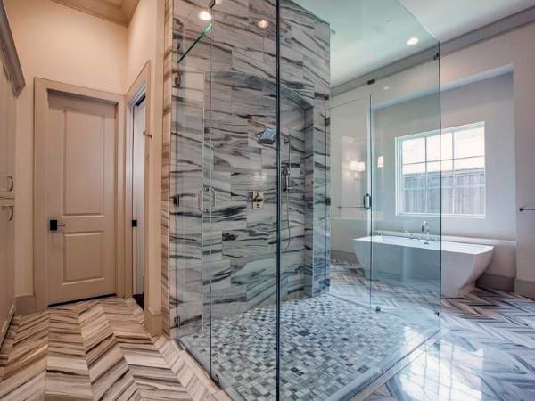 Marble tile bathroom with shower and freestanding bathtub.