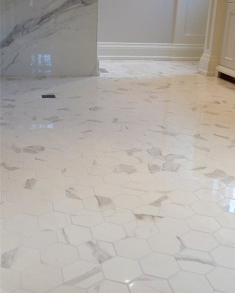 Bathroom with white hexagonal marble floor tiles and light grey veining patterns.