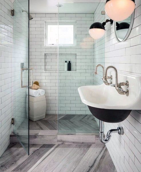 Contemporary bathroom with glass shower, white sink, and wood-look tile floor.