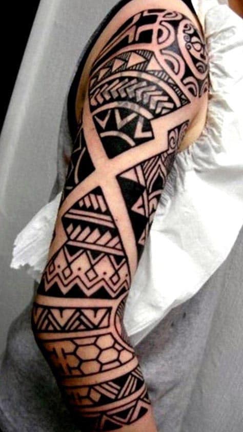 Arm with an intricate tribal tattoo sleeve design in black ink