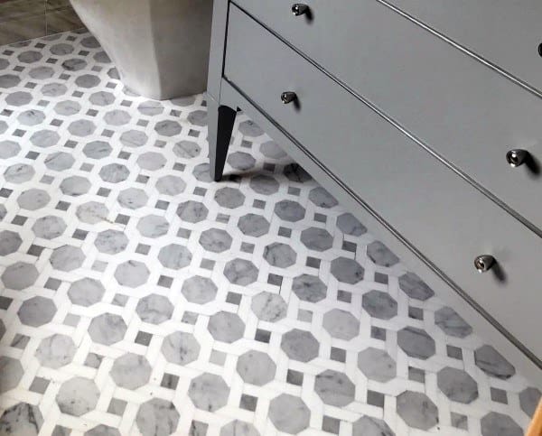 Hexagonal patterned grey and white marble bathroom floor tiles.