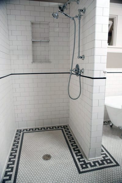 Small shower with white subway tiles and hexagonal mosaic floor tiles with a black border.