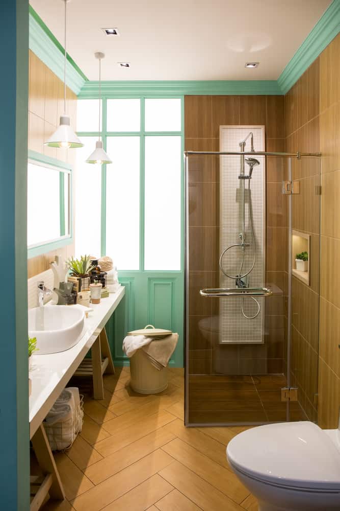 Modern bathroom with wood-paneled shower, mint green accents, and sleek fixtures.