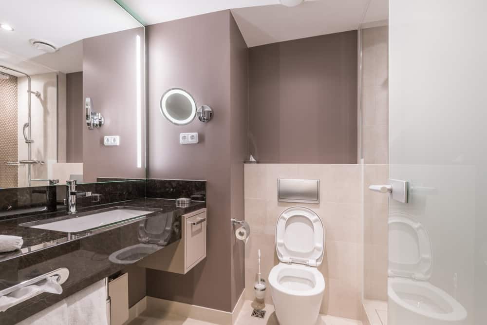 Contemporary bathroom with large mirror, sleek vanity, and neutral-toned walls.