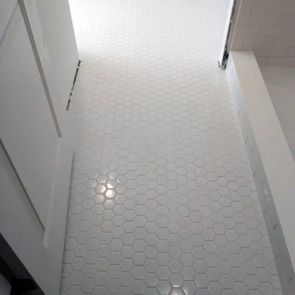 Bathroom with small white hexagonal floor tiles and a clean, minimalist design.