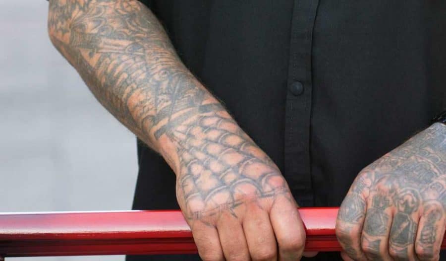 Individual with intricate tattoos on arms and hands