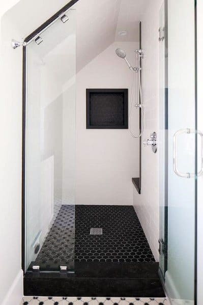 Small modern shower with black hexagonal floor tiles and a built-in wall niche.